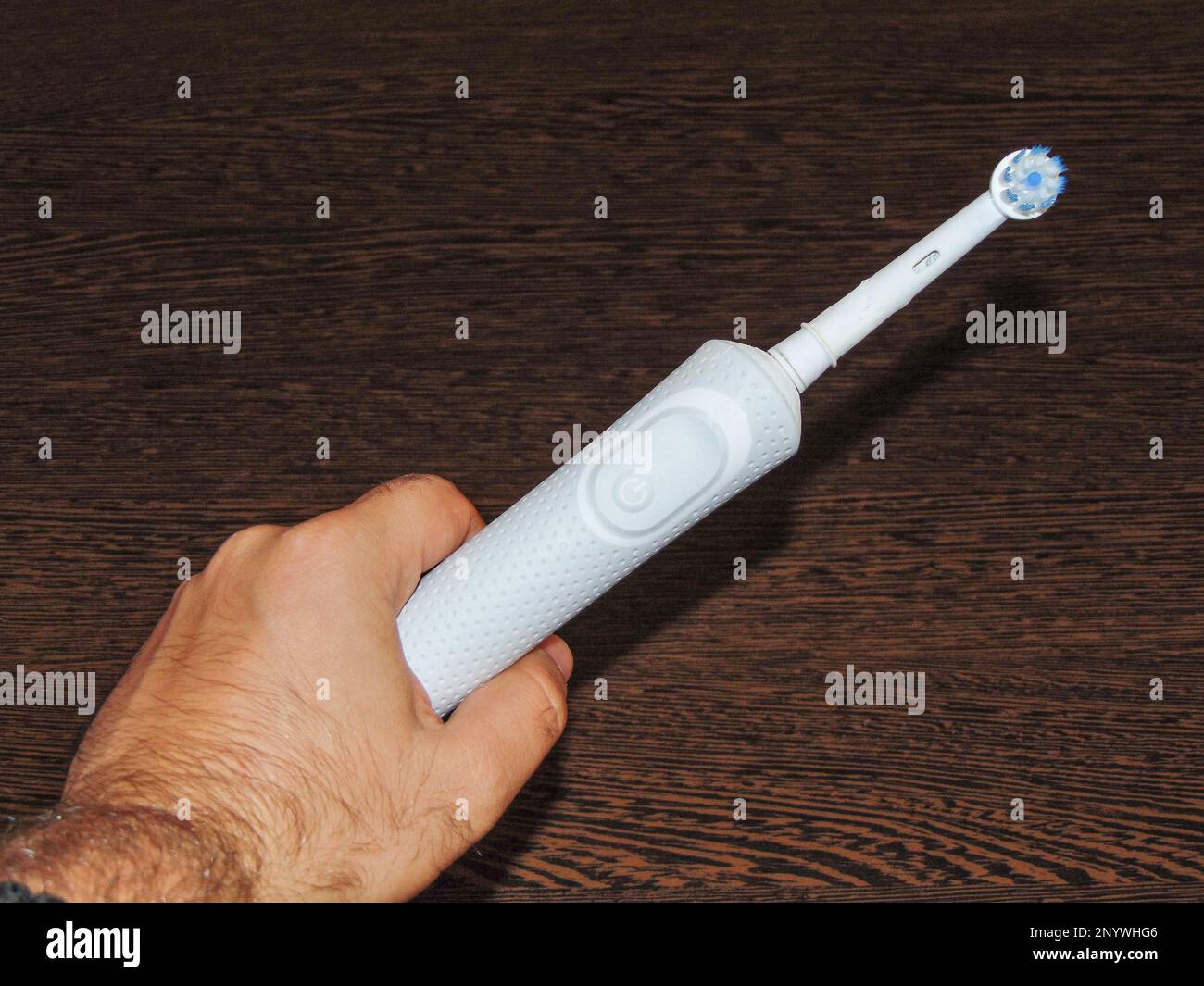 white electric toothbrush in one hand Stock Photo