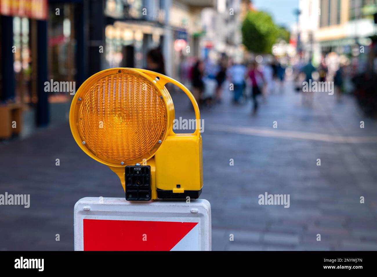 Orange signal lamp warning of danger in the pedestrian zone. Selective focus. Stock Photo