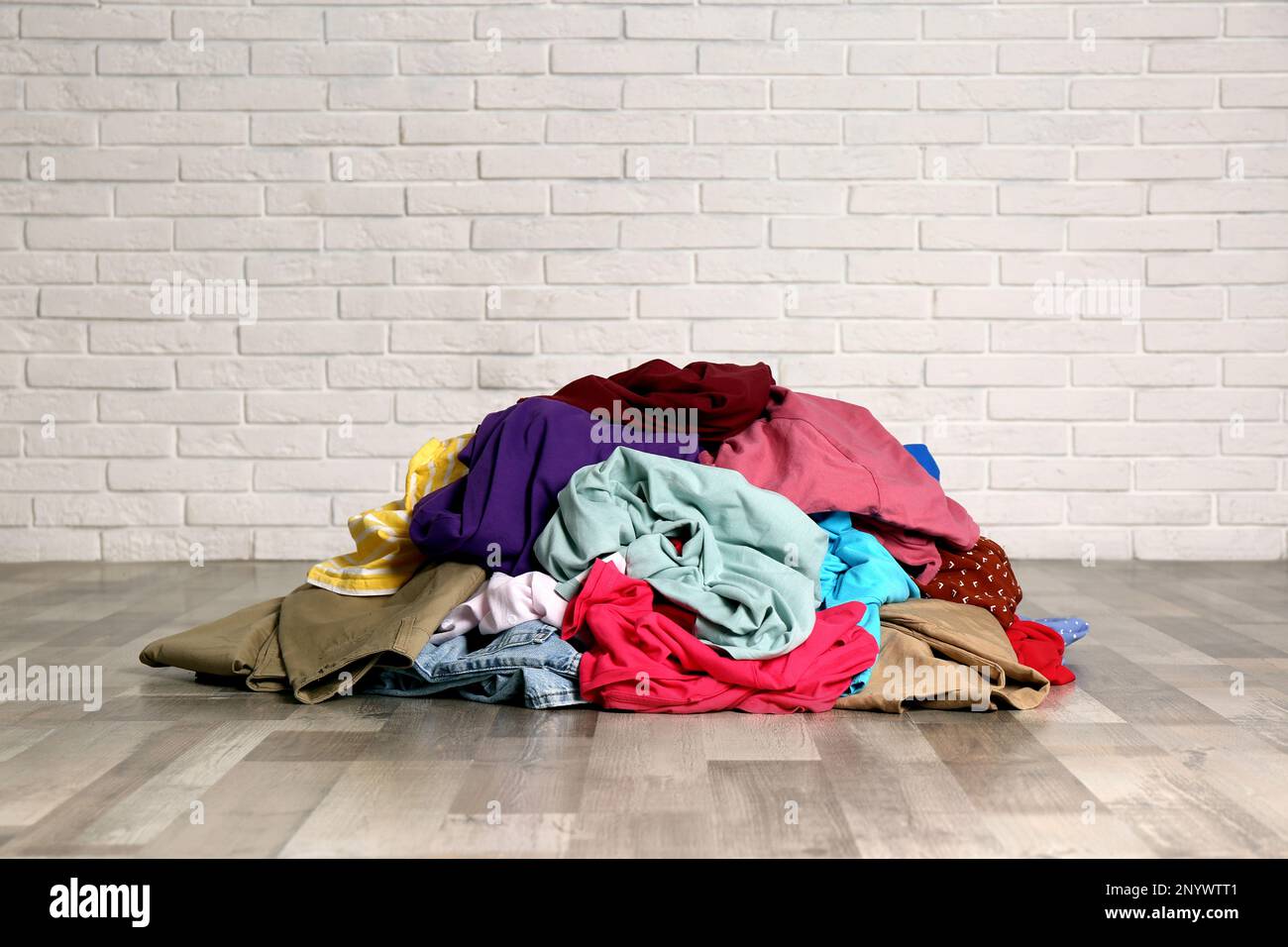 Pile of dirty clothes on floor near brick wall Stock Photo Alamy
