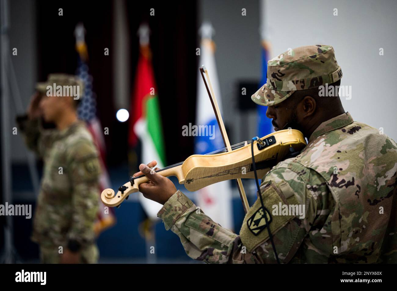 U.S. Army Sgt. 1st Class Myles Moore, assigned to the 4th Battalion 3rd Air Defense Artillery Regiment (4-3 ADA), performs the U.S. National Anthem on the violin during the 4-3 ADA transfer of authority ceremony, Jan. 26, 2023. The 4-3 ADA transferred responsibility of the MIM-104 Patriot missile systems at Al Dhafra AB to the 2nd Battalion 43rd Air Defense Artillery Regiment before returning to garrison at Ft. Sill, Oklahoma. Stock Photo