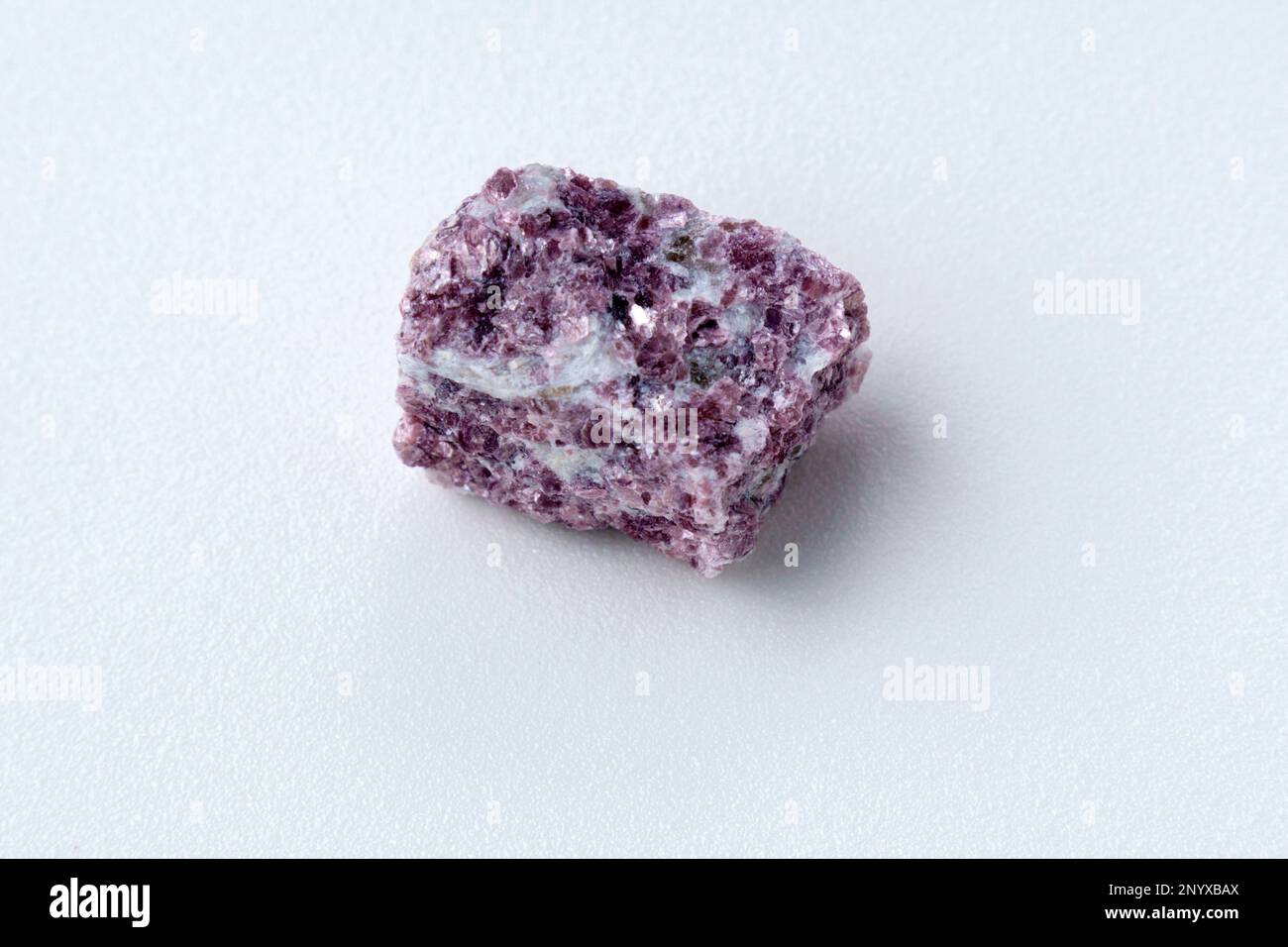 Mineral stone lepidolite. Macro shooting of natural gemstone. The raw mineral, white backround Stock Photo