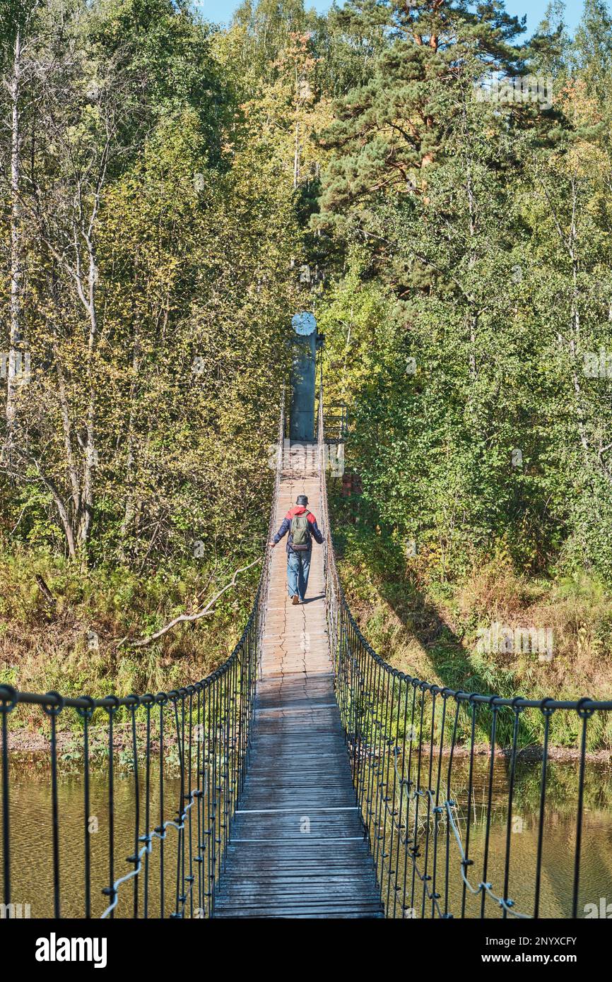 Senior man on suspension bridge in nature park. Back view Stock Photo ...