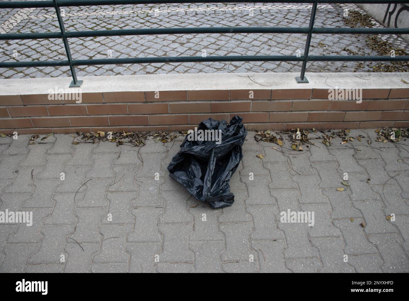 discarded black plastic sack for garbage dumped on the street Stock Photo