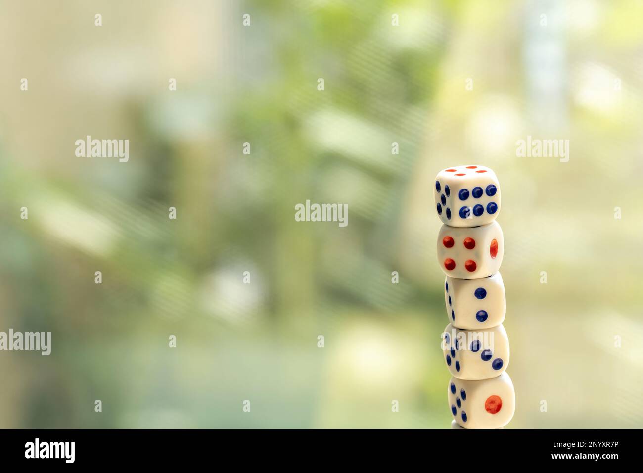 Stack tower of many small game dice isolated on a bright blurred background, group of objects, nobody. Probability and chance multiple random numbers, Stock Photo