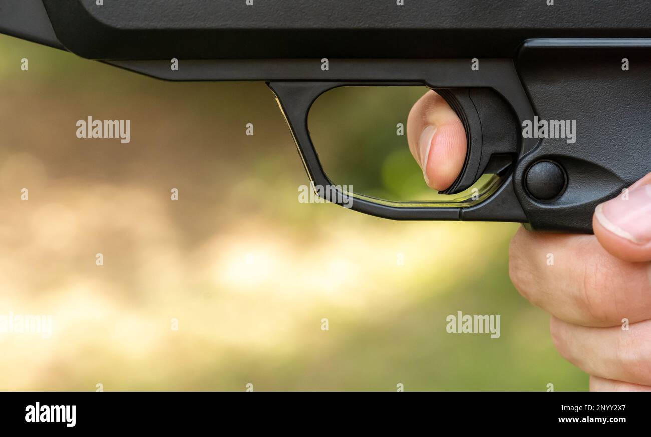Man pulling the trigger of an air gun airgun, firing a pneumatic weapon