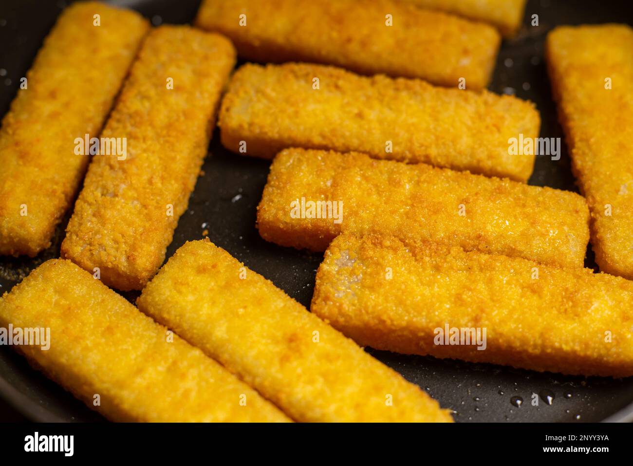 Fish sticks in a pan. Preparation of frozen fish sticks. Fast food
