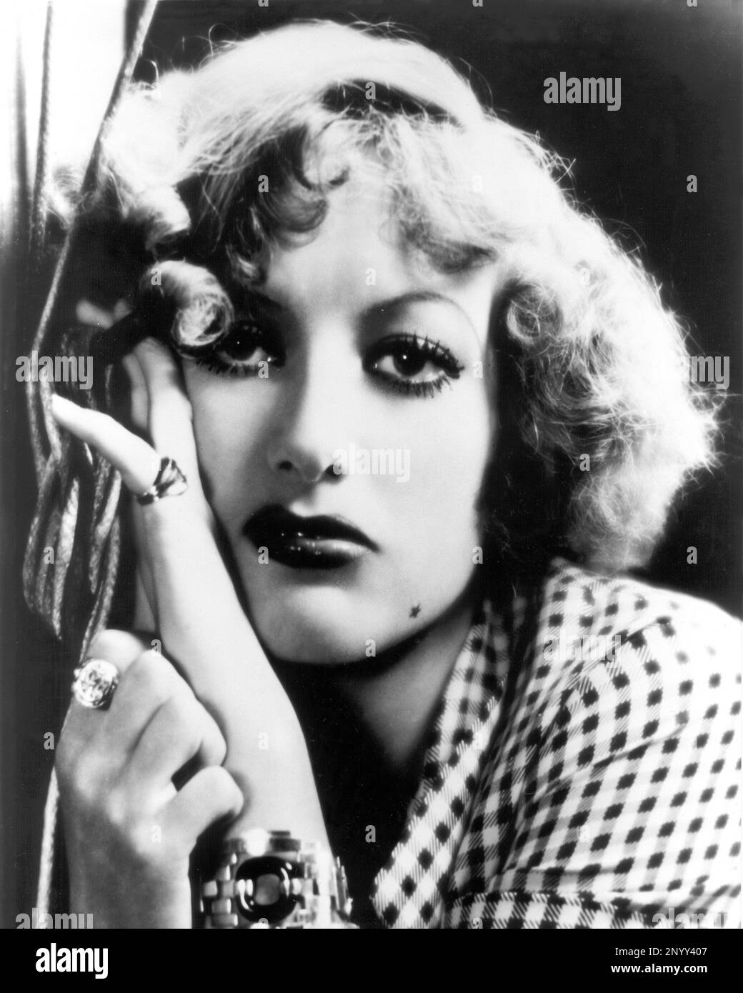 1932 , USA : The movie actress JOAN  CRAWFORD in RAIN ( Pioggia ) by Lewis Milestone , from a story by W. Somerset Maugham  - FILM - CINEMA - portrait - ritratto - gioiello - gioielli - jewels - ring - anello - neo - mole - stella - star - bijoux - bracelet - braccialetto - DIVA - DIVINA - VAMP - bionda - blonde  hair - capelli biondi   ----  Archivio GBB Stock Photo