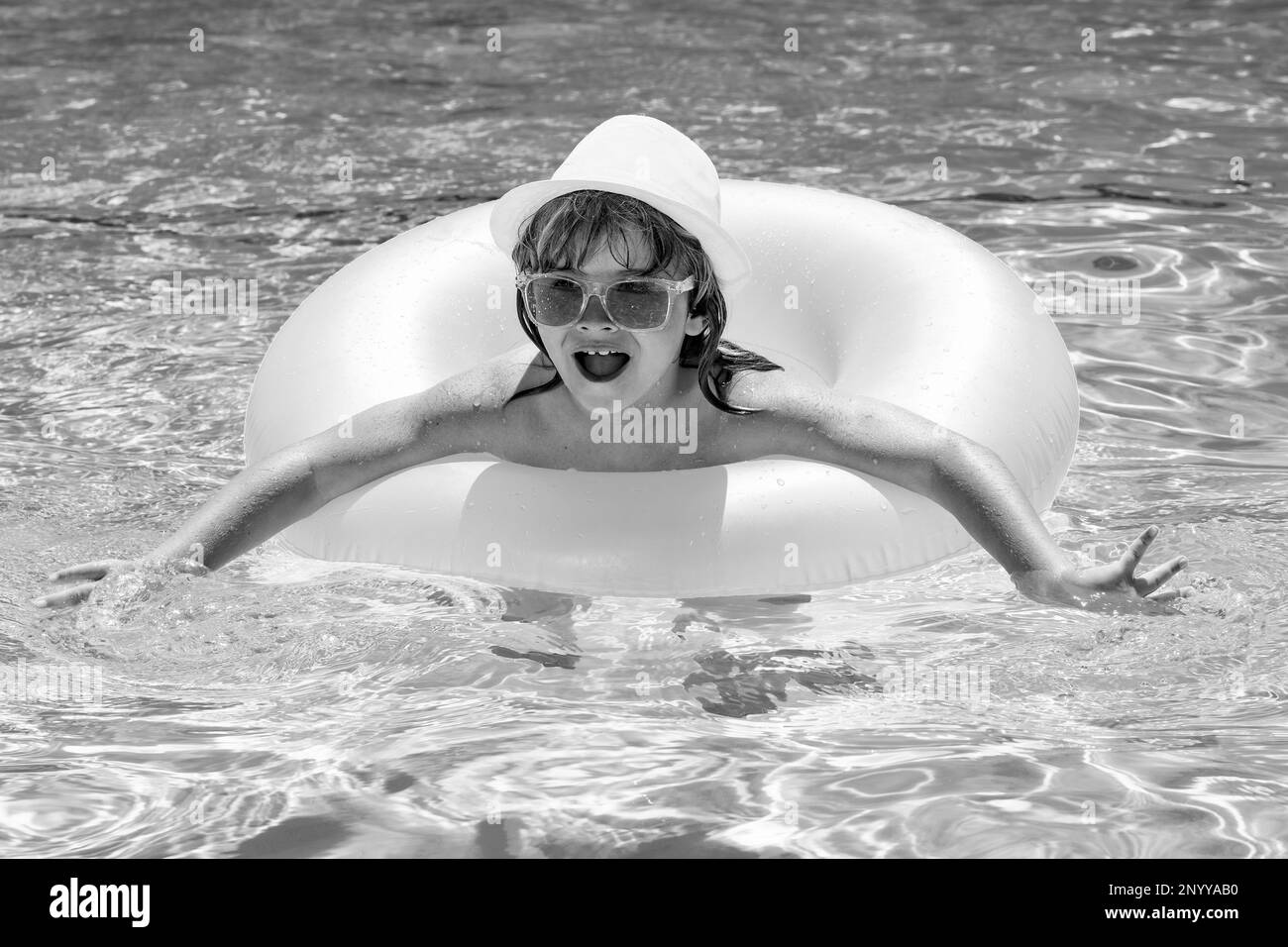 Child splashing in swimming pool. Active healthy lifestyle, swim water