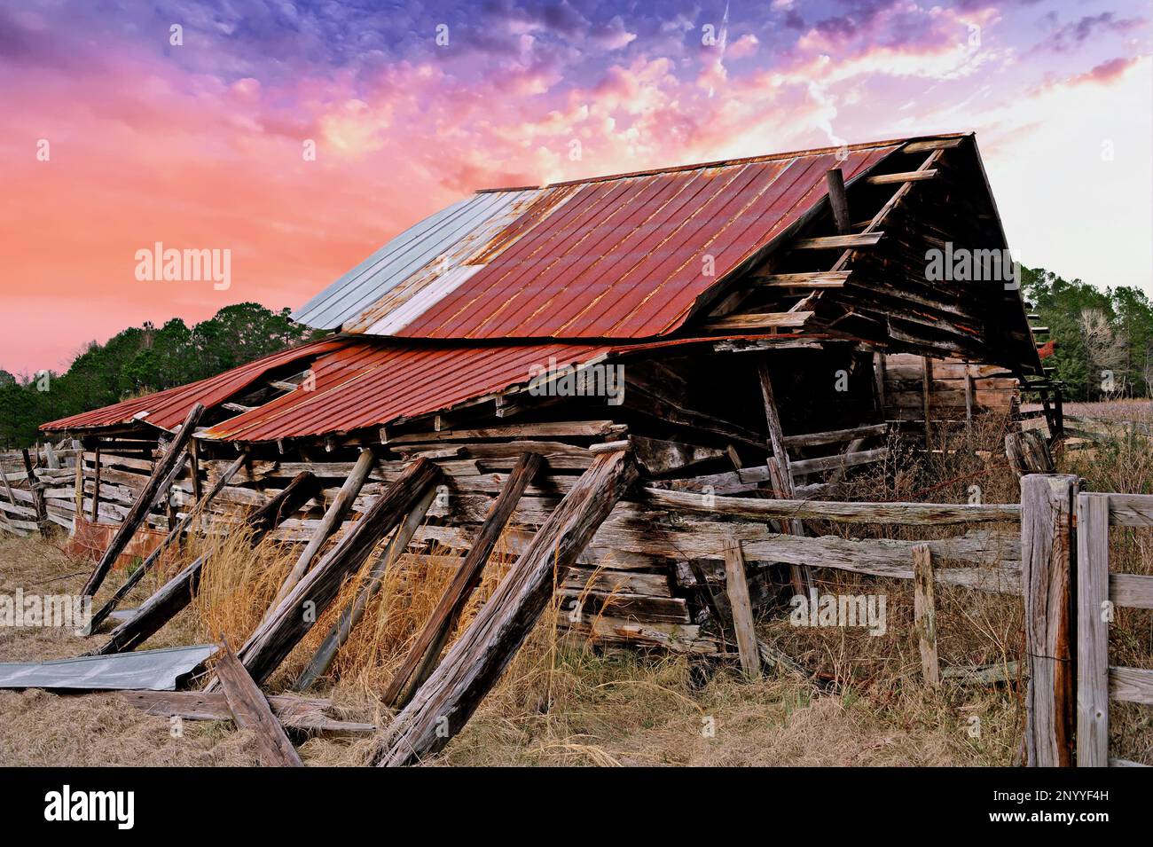 An Old Abandoned Run Down Barn in a Field at Sunset Stock Photo