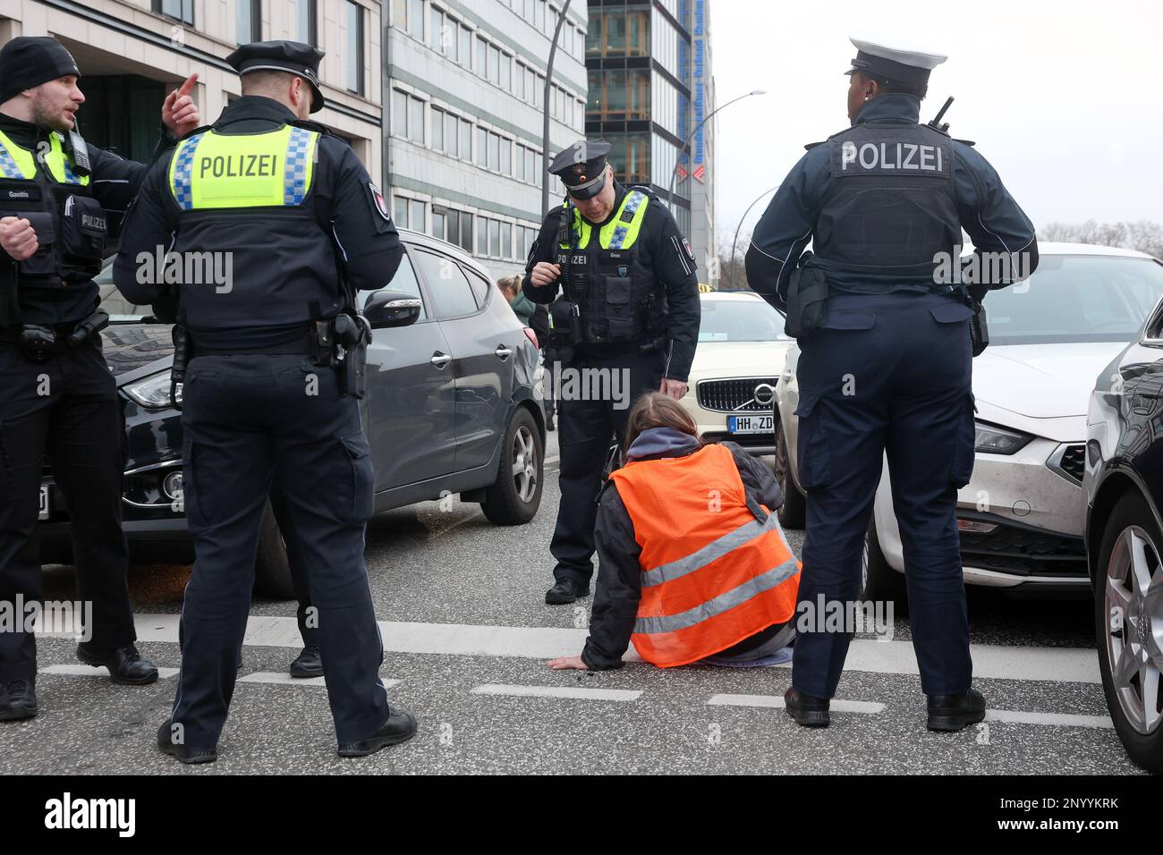 Hamburg, Germany. 02nd Mar, 2023. Activists of the environmental group 'Last Generation' who have stuck themselves on the Glockengießerwall near the main station are surrounded by police officers. They want to draw attention to the compliance with climate targets. Credit: Bodo Marks/dpa/Alamy Live News Stock Photo