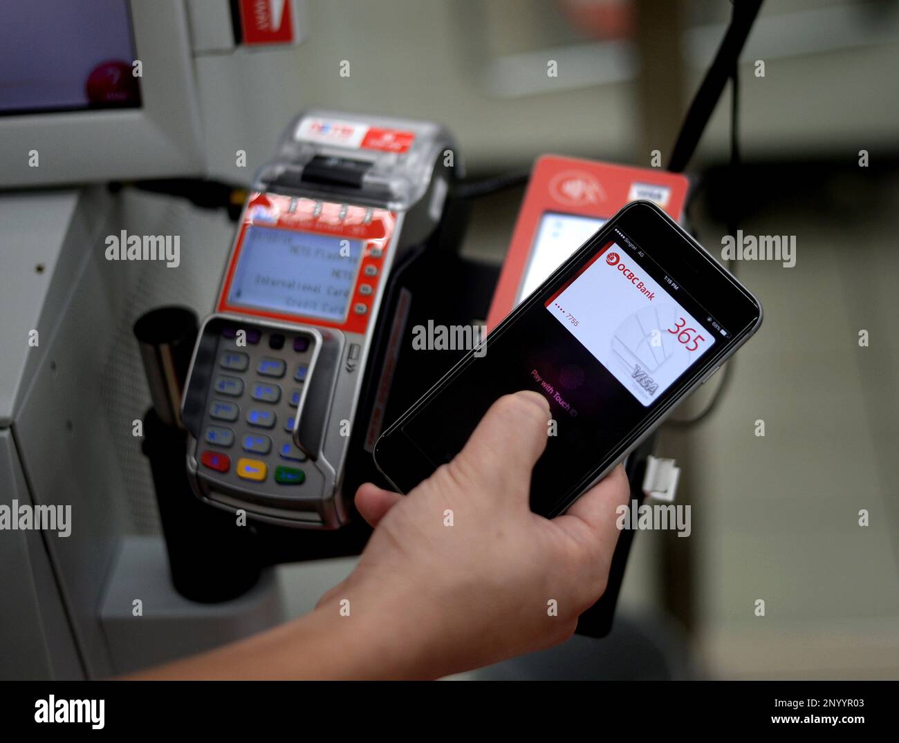 A customer using Apple Pay to pay at the self checkout counter at NTUC  FairPrice Xtra in NEX . Apple Pay, Samsung Pay and Android Pay offer  consumers in Singapore a plethora