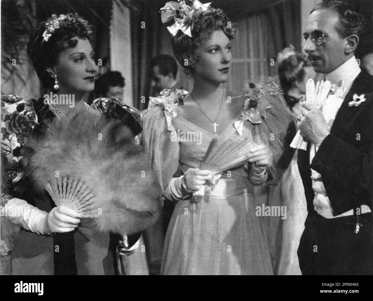 1943 : The italian theatre and movie actress TINA LATTANZI ( Alatri 15 february 1902 - Roma 25 october 1997 ), the voice of Greta Garbo , Joan Crafword and Marlene Dietrich in the italian editions of Hollywood movies . In this photo with VALENTINA CORTESE ( at center ) in LA CARICA DEGLI EROI by Oreste Biancoli and Anton Giulio Majano   - TEATRO - THEATER - portrait - ritratto - CINEMA   - ANNI QUARANTA - 40's - '40 - eardrops - orecchino - orecchini - fan - ventaglio - feathers - piume - chignon  - jewels - jewellery - gioielli - gioiello - DOPPIAGGIO - DOPPIATORE - DOPPIATRICE  ----  Archivi Stock Photo