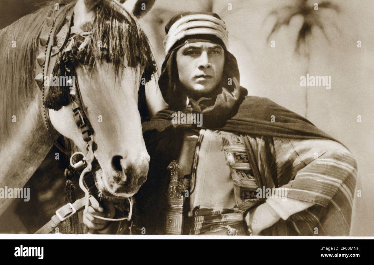 1926 : The silent screen movie actor RUDOLPH VALENTINO ( born Rodolfo Guglielmi , 1895 - 1926 )  in THE SON OF THE SHEIK ( Il figlio dello Sceicco ) by George Fitzmaurice , from the novel by Edith Maude Hull , Paramount Picture . In this movie Valentino mounted the horse named JADAAN , a grey stallion - CINEMA MUTO -  RODOLFO - attore cinematografico - VILMA - LATIN LOVER - italoamericano - italo americano - italo-americano - emigrant - emigrante - italo-american - portrait - ritratto - turbante - turban  - arab - arabo - cavallo - ippica - cavaliere - mantello - mantle - cavallerizzo - desert Stock Photo