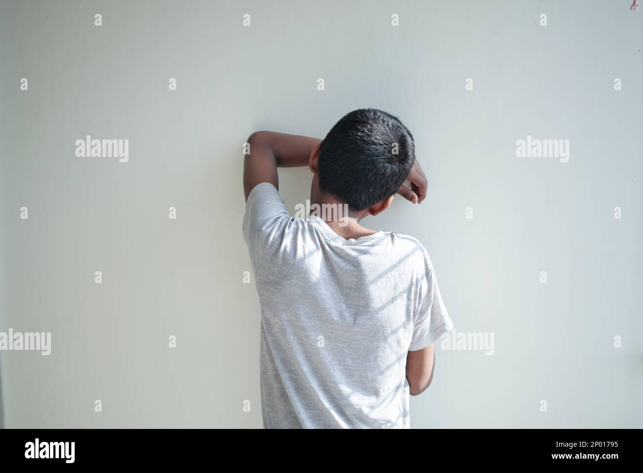 sand boy hiding his face against wall Stock Photo - Alamy