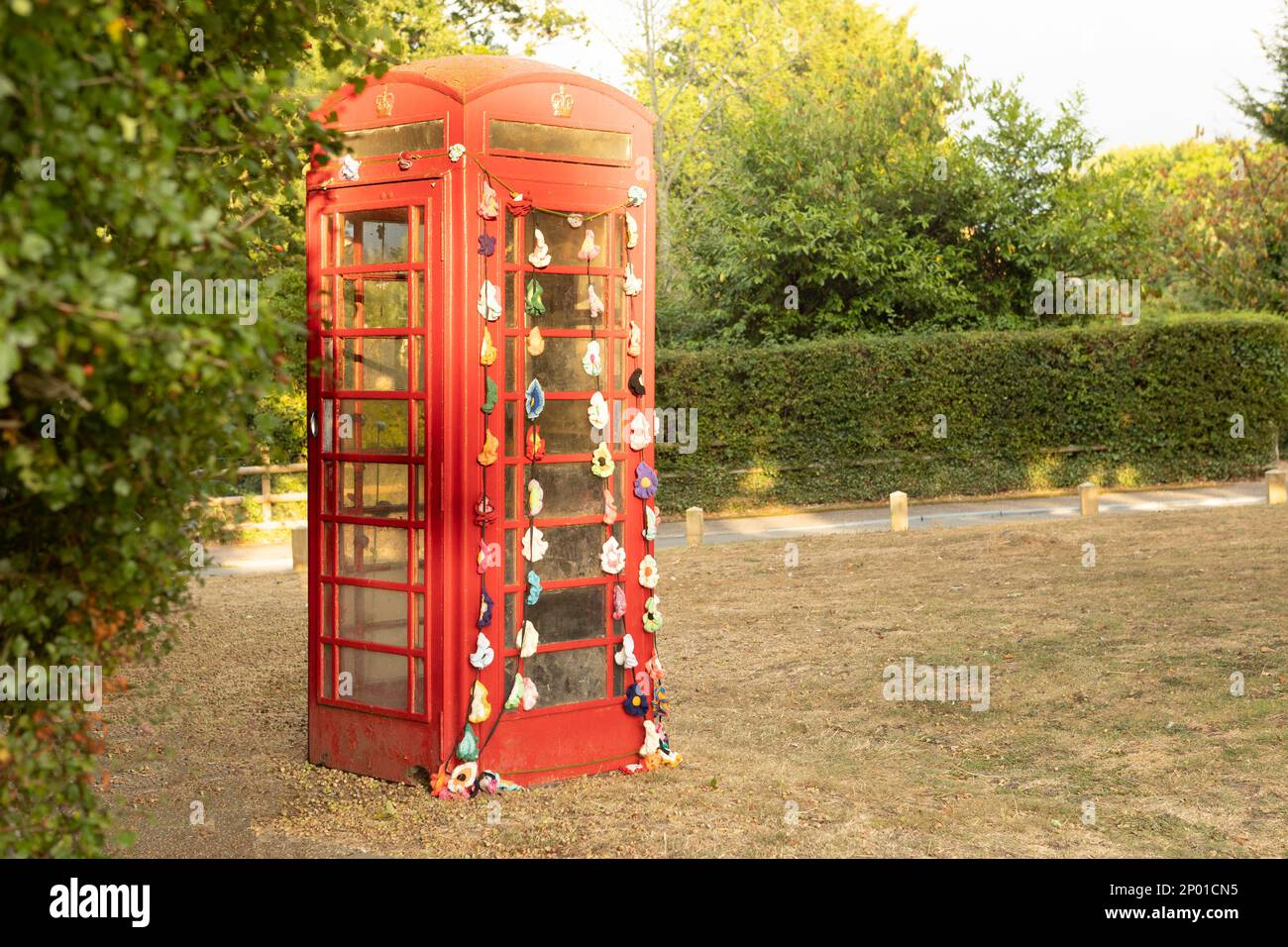 High Halden, Kent, united kingdom, 21, August, 2022, decorated english red phone box on the edge of a village green , early evening light Stock Photo