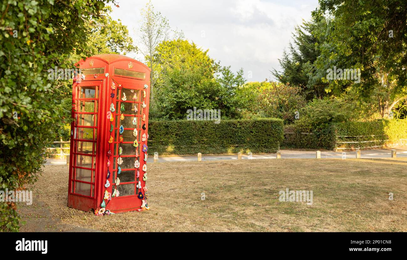 High Halden, Kent, united kingdom, 21, August, 2022, decorated english red phone box on the edge of a village green , early evening light Stock Photo