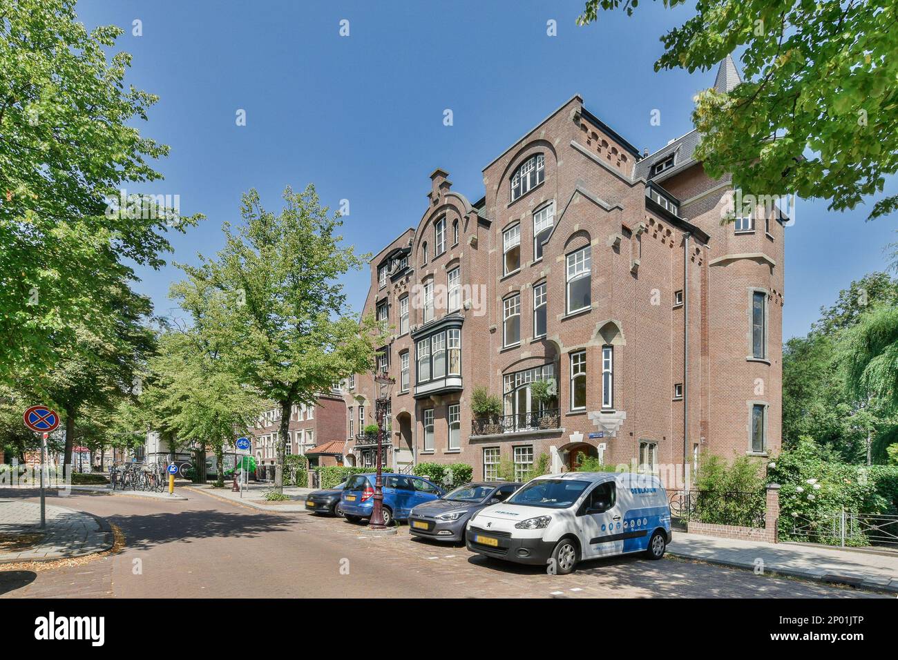 a city street with cars parked on the side and trees lining the street ...