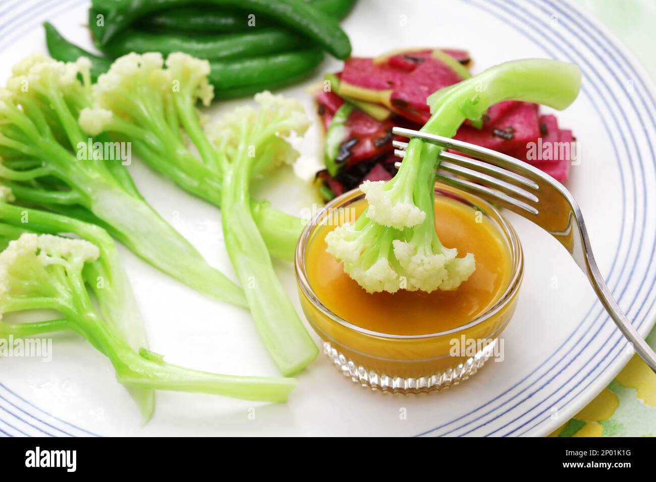 Three kinds of vegetable salad; baby stick cauliflower, watermelon radish, and snap peas Stock Photo