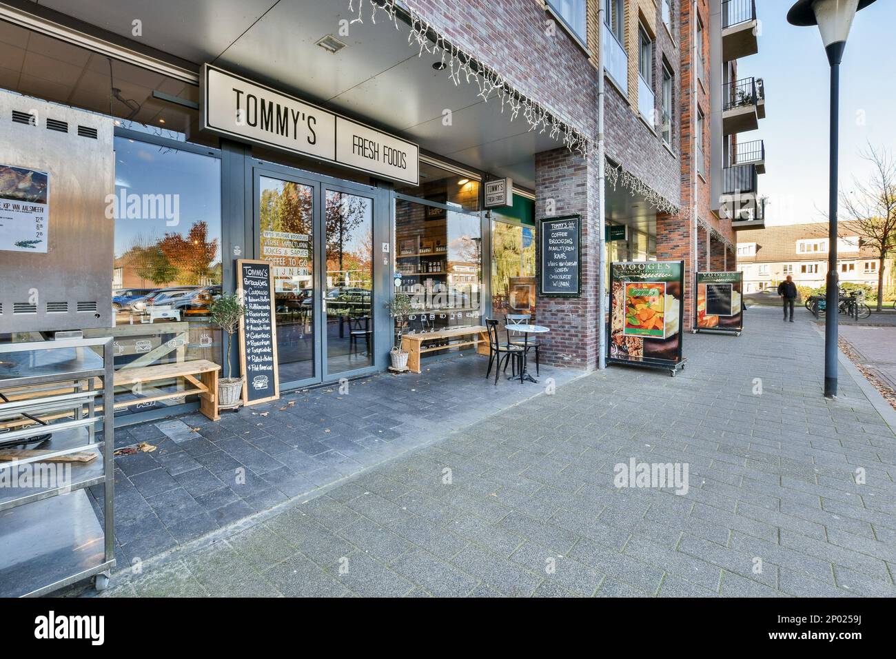 Amsterdam, Netherlands - 10 April, 2021: the outside of a restaurant with tables and benches on the sidewalk in front of an old brick building that says tom's Stock Photo