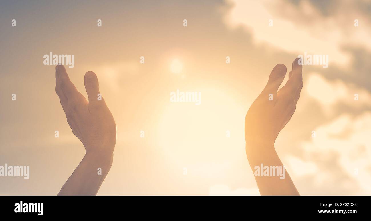 Female lifting hands up to sunset sky. Happiness and feeling grateful concept. Stock Photo