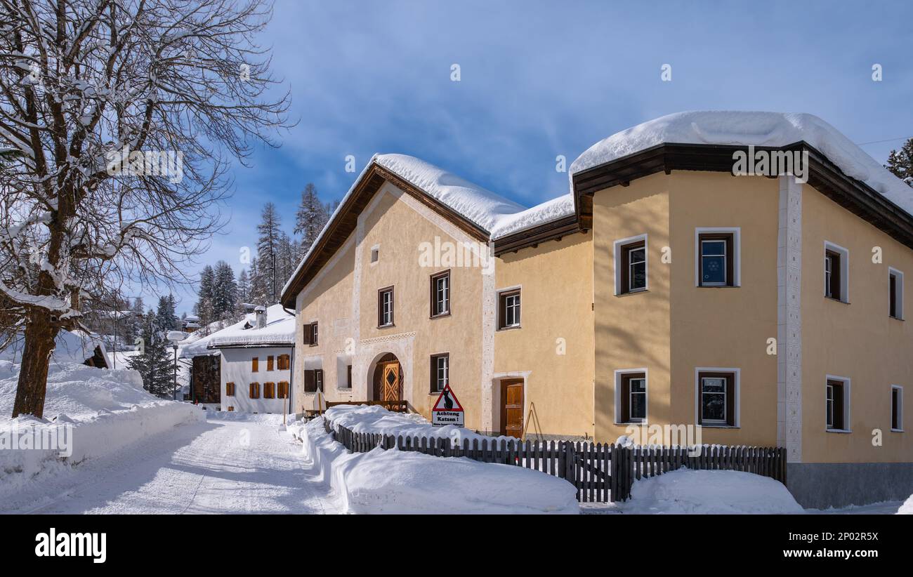 Cinuos-Chel, Switzerland - February 3, 2022: Snow covered village of Cinuos Chel and typical traditional historical houses in Engadine, Graubunden, Sw Stock Photo