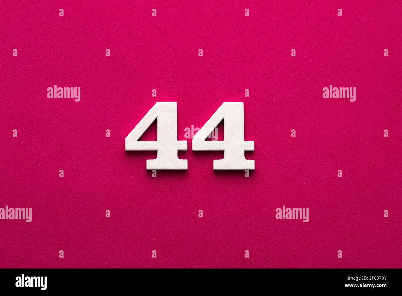 Number 44 White wooden number on rhodamine red background Stock Photo