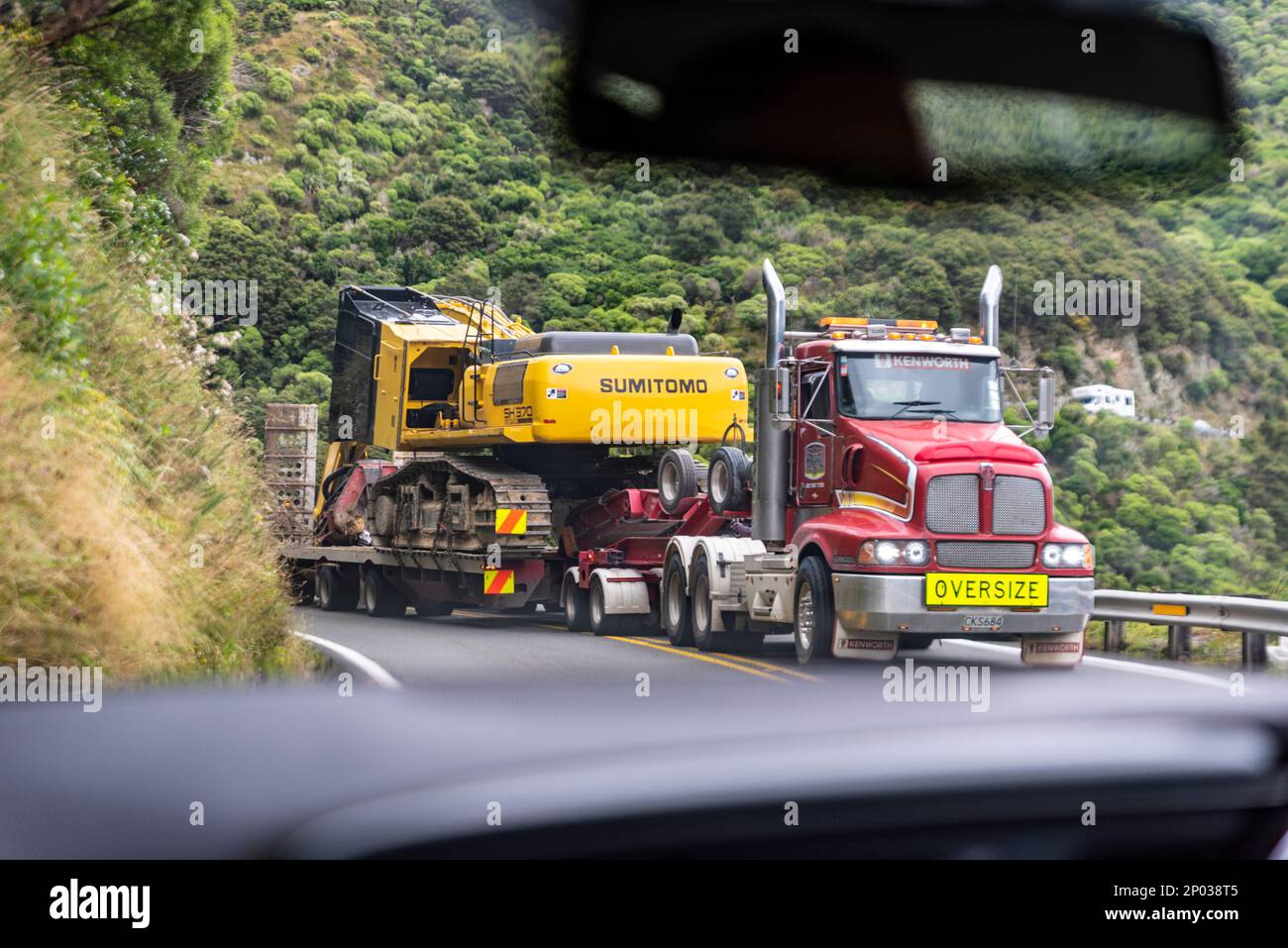 In car, with oversize load taking both lanes of road over the Remutaka
