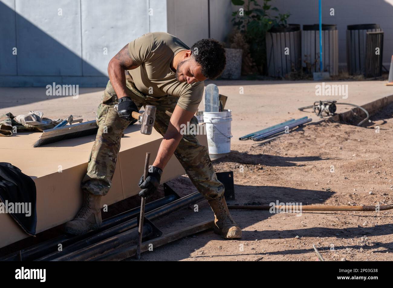 Senior Airman Jeremy Padin, assigned to the 355th Civil Engineer Squadron, hammers a metal rod at Davis-Monthan Air Force Base, Ariz., Jan. 17, 2023. Padin took part in the project to create a drill pad for the DM honor guard team. Stock Photo