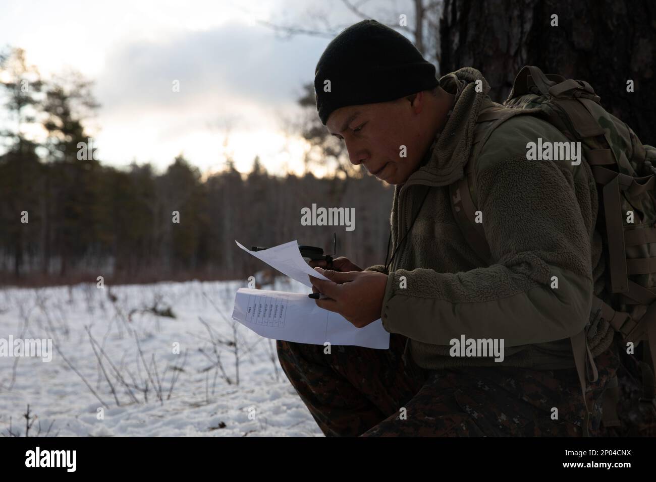 Sgt. Marcos Cruz, El Salvador Special Forces, estimates his location and uses his compass to find his next point during the land navigation portion of the New Hampshire National Guard Best Warrior Competition, Feb. 11, at the Edward Cross Training Complex in Pembroke, N.H. Stock Photo