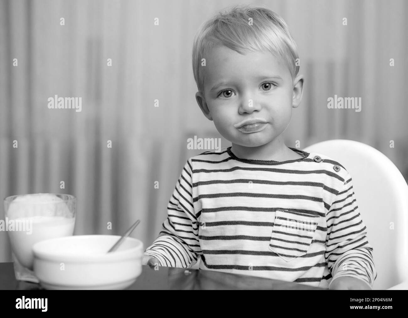 Toddler having snack at home. Boy cute baby eating breakfast. Child eat