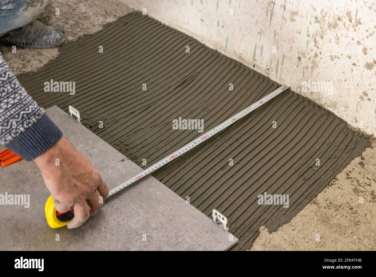 industrial ceramic builder worker installing floor tile at repair
