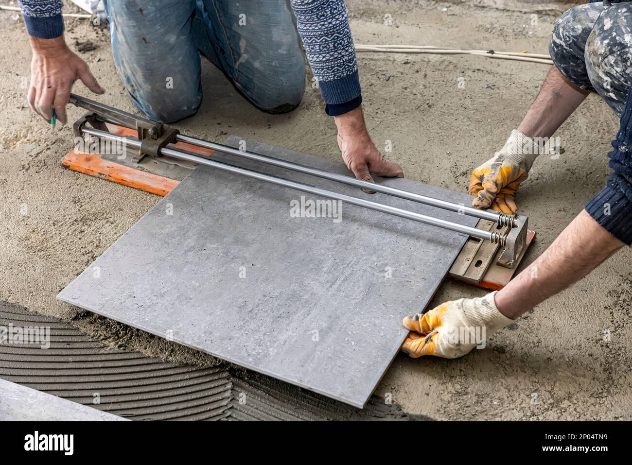 industrial ceramic builder worker installing floor tile at repair