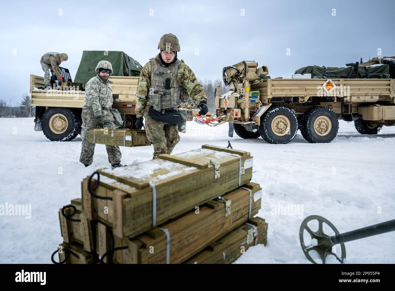 Army Sgt. Meranda Leisgana and Sgt. Trayton Pankratz, 1-120th Field Artillery Regiment, carries a wooden crate of 105mm High Explosive shells for the M119 howitzer during Northern Strike 23-1, Jan. 25, 2023, at Camp Grayling, Mich. Units that participate in Northern Strike’s winter iteration build readiness by conducting joint, cold-weather training designed to meet objectives of the Department of Defense’s Arctic Strategy. Stock Photo