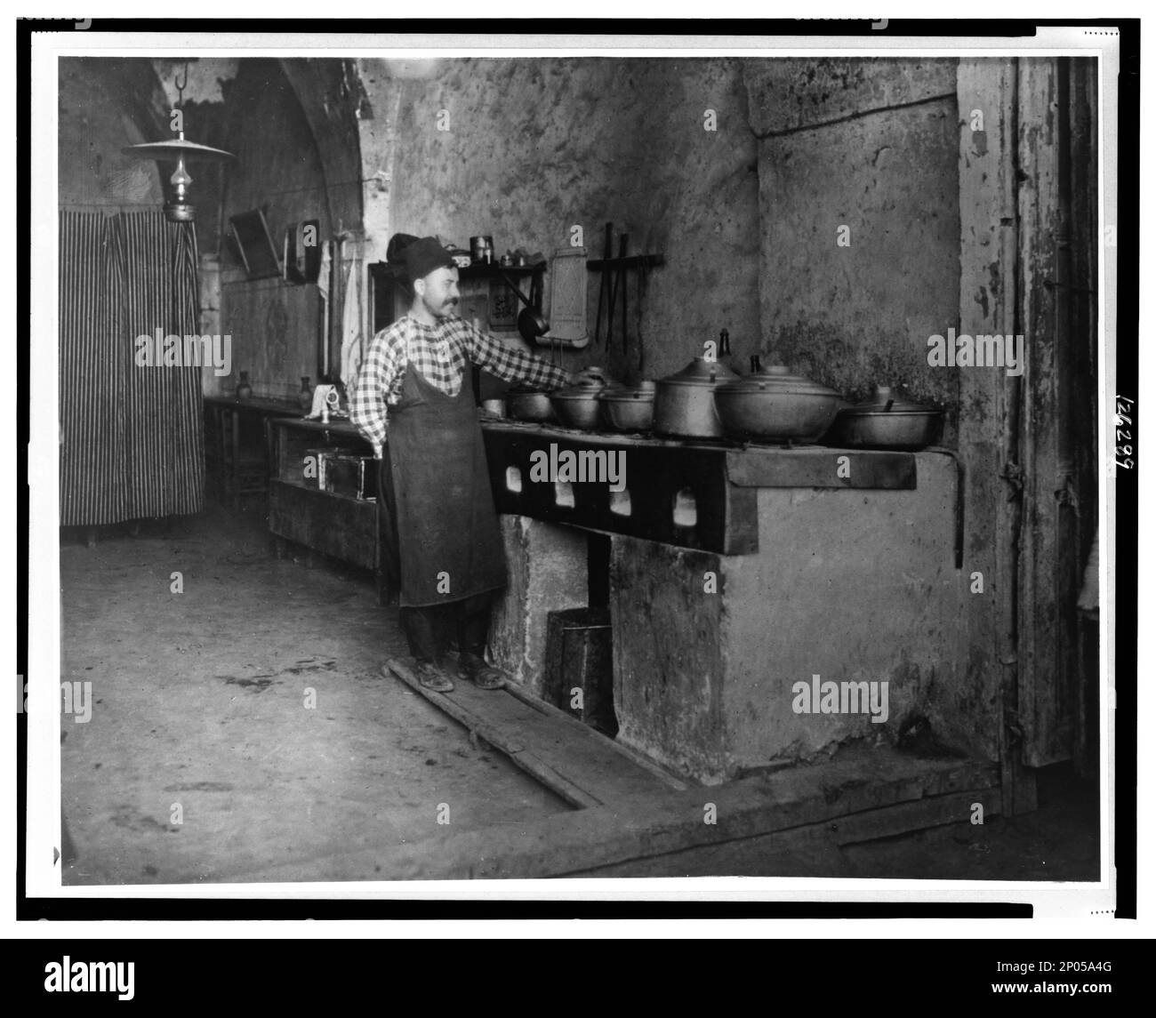 Palestine - Jerusalem--Food being cooked over a limestone slab in a Turkish restaurant. Frank and Frances Carpenter Collection , Cookery,Jerusalem,1880-1920, Stoves,1880-1920, Restaurants,Jerusalem,1880-1920. Stock Photo