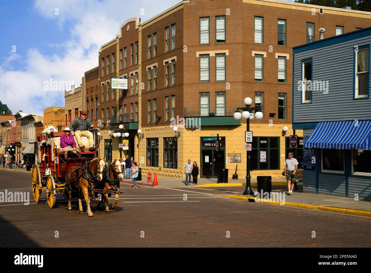 An old-fashioned stagecoach carries tourists down historic Main St. in the Black Hills gold rush town of Deadwood, South Dakota. Stock Photo