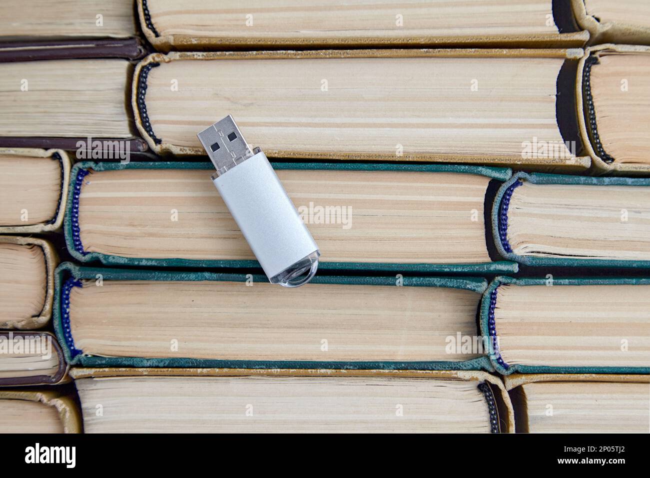USB flash drive of a computer on the background of a stack of old paper