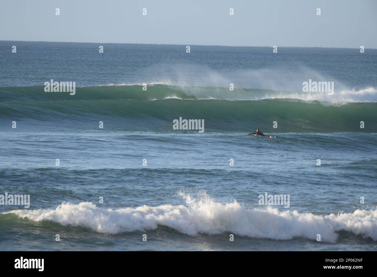 Surfing near Jan Juc on the surf coast a lone surfers paddles out to