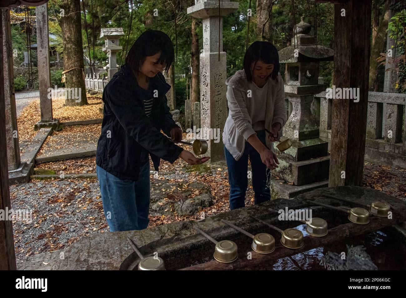 Japanese girls at temizuya ritual purification ceremony, Kamiichinomiya Oawa Shrine, Kamiyama, Shikoku Island, Japan Stock Photo