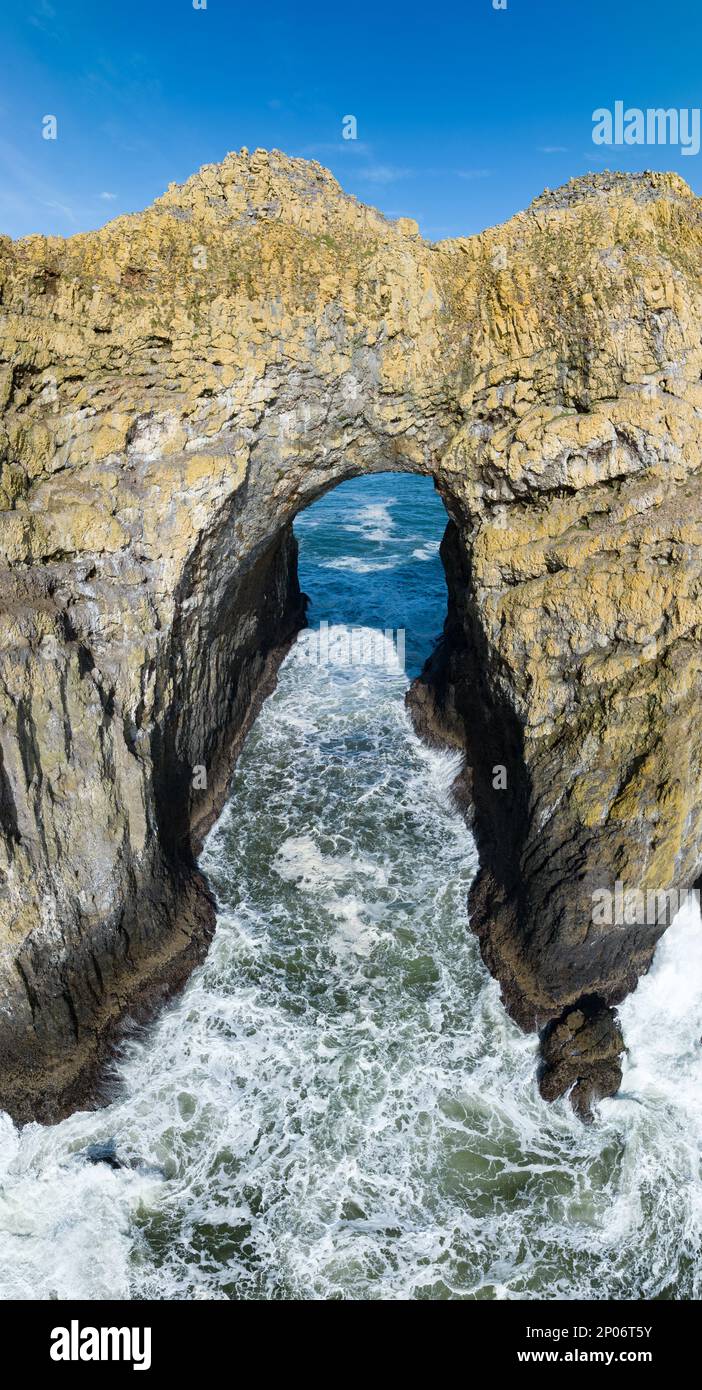 The Pacific Ocean washes through a rocky, natural arch off the scenic, northern coast of Oregon, not far from the town of Tillamook. Stock Photo