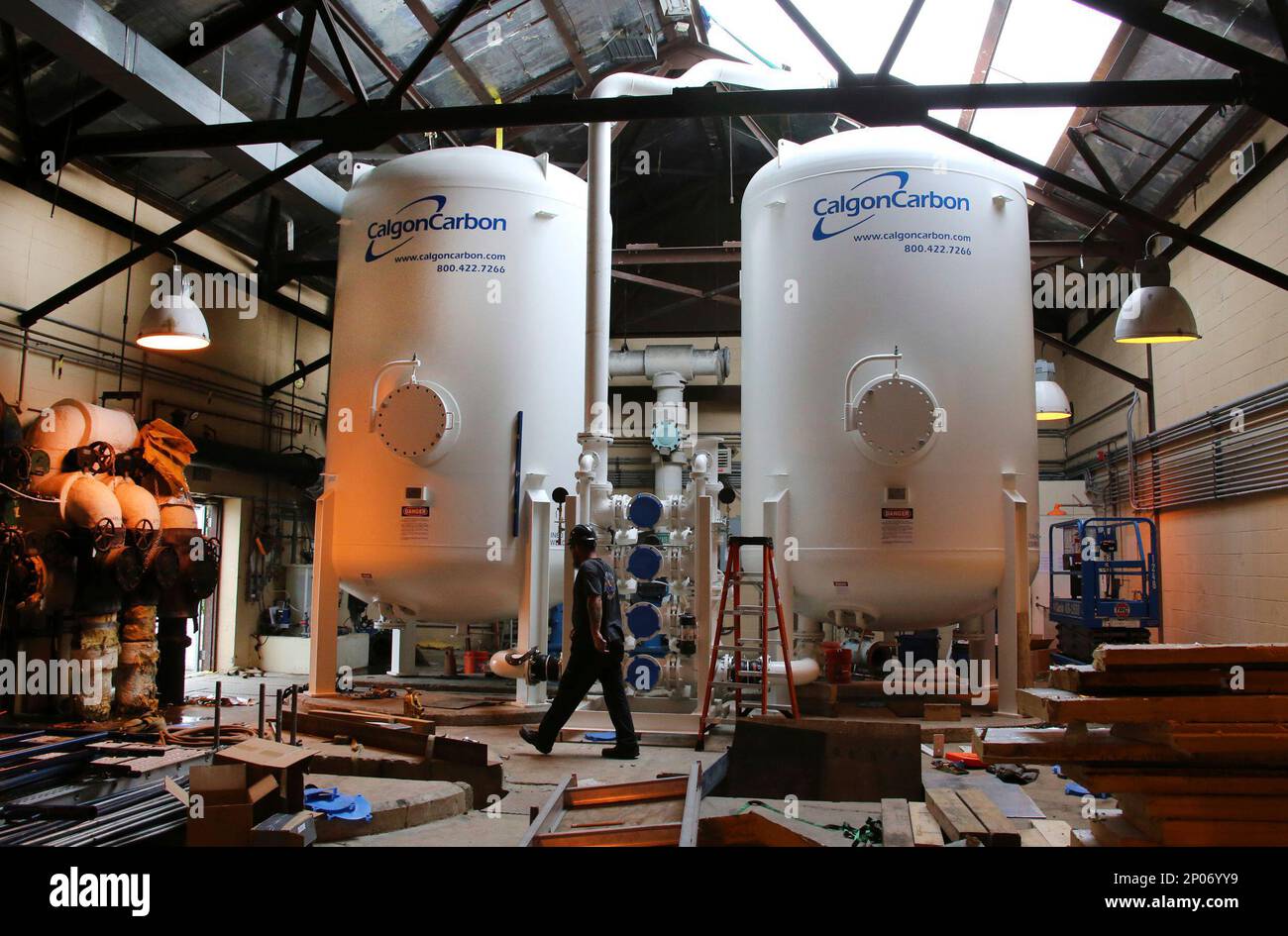 In this July 14, 2016 photo, a worker walks by two large carbon