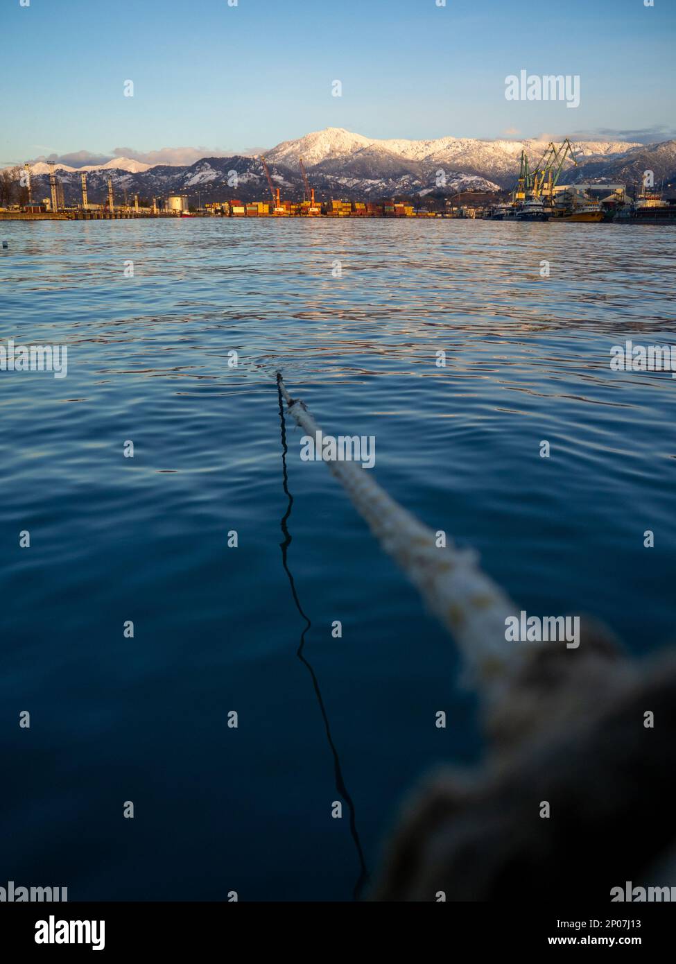 rope goes into the water from the bollard. Attaching boats to the pier ...