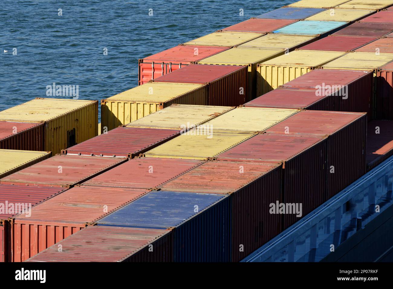 many colorful containers on a river freighter on the rhine on a sunny day Stock Photo