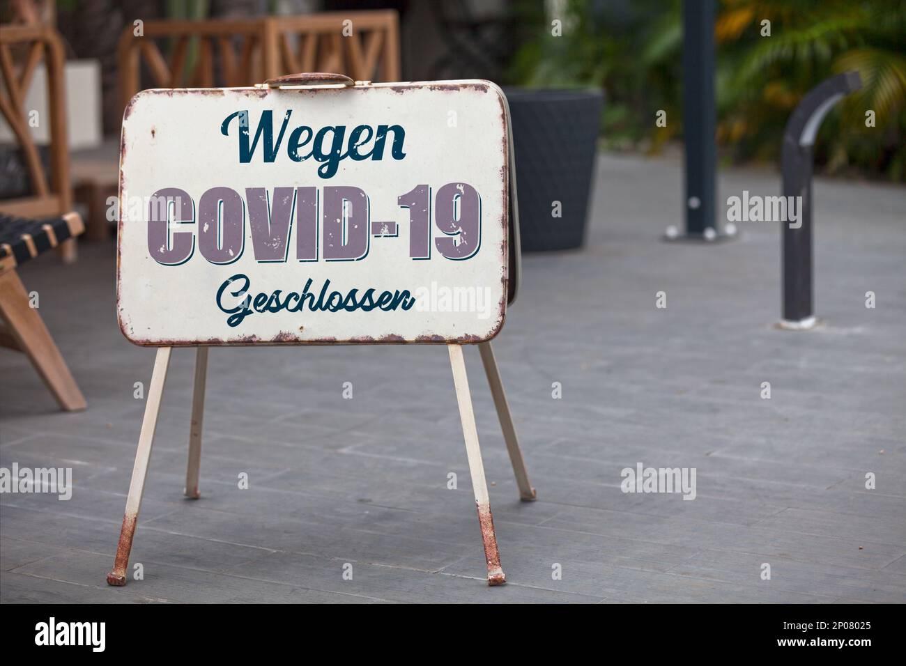 Outdoor open sign with written in it in German 'Wegen COVID-19 Geschlossen' meaning in English 'Closed due to COVID-19'. Stock Photo