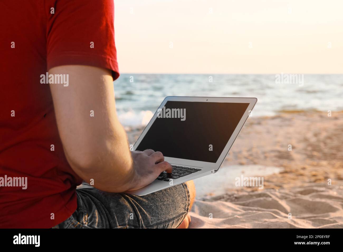 Man working with laptop on beach, closeup Stock Photo
