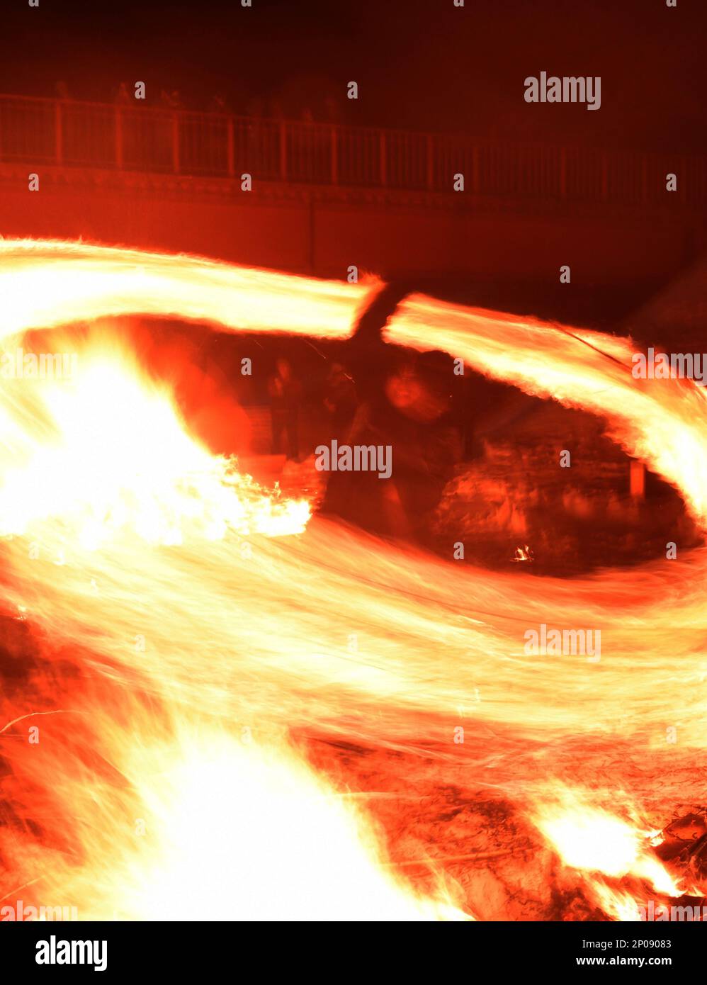 A performer create a fire ring by swing bales of burning straw during ...