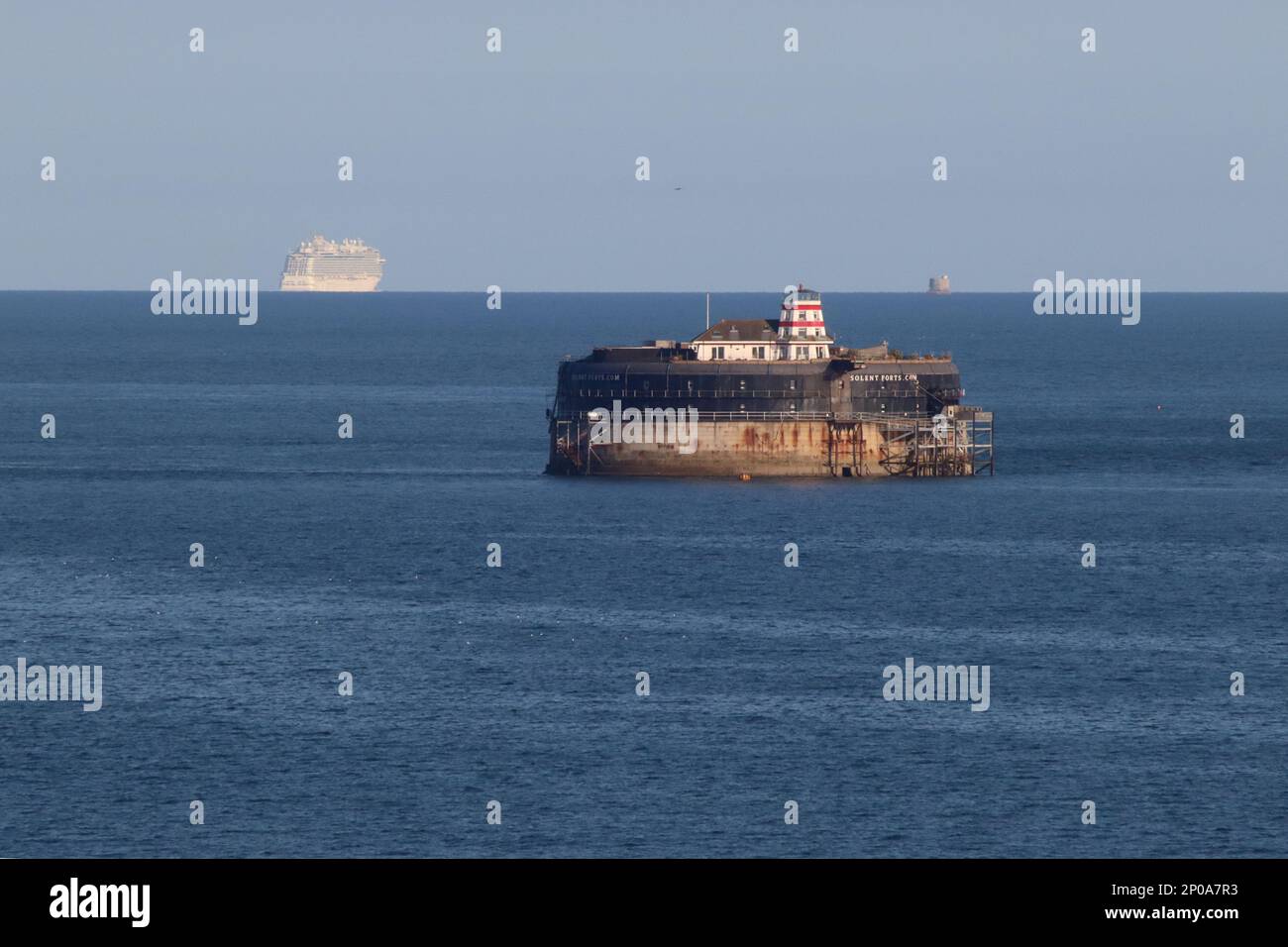 A Solent view - No Man's Land Fort in the foreground, while on the horizon, the Enchanted Princess cruise ship and Nab tower August 2022. Stock Photo