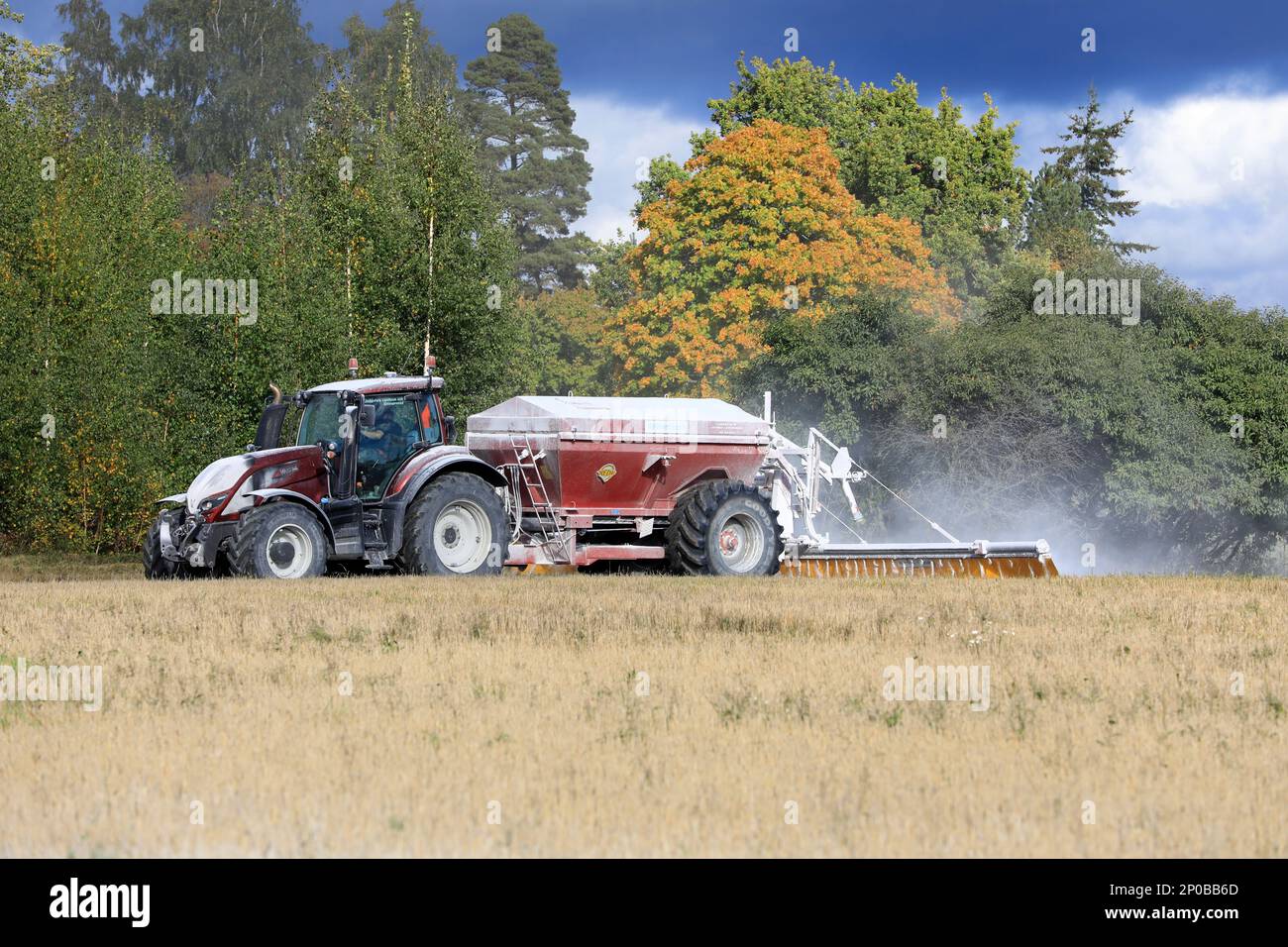 Valtra tractor spreading Nordkalk agricultural lime, a soil additive made from pulverized limestone or chalk. Raseborg, Finland. September 23, 2022. Stock Photo