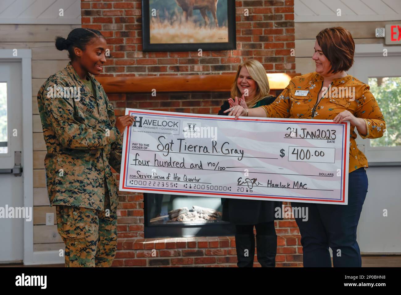 Erin Knight, the executive director of the Havelock Chamber of Commerce Military Affairs Committee, along with Kim Smith, present U.S. Marine Corps Sgt. Tierra R. Gray, an administrative specialist with 2d Low Altitude Air Defense (2D LAAD) battalion, a ceremonial award check in the amount of $400 for service person of the quarter at Marine Corps Air Station Cherry Point, North Carolina, Jan. 24, 2023. Gray was recognized for her dedication to volunteering at Roger Bell New Tech Academy. As a volunteer, she provides mentorship to students and helps them set and achieve their goals. Stock Photo