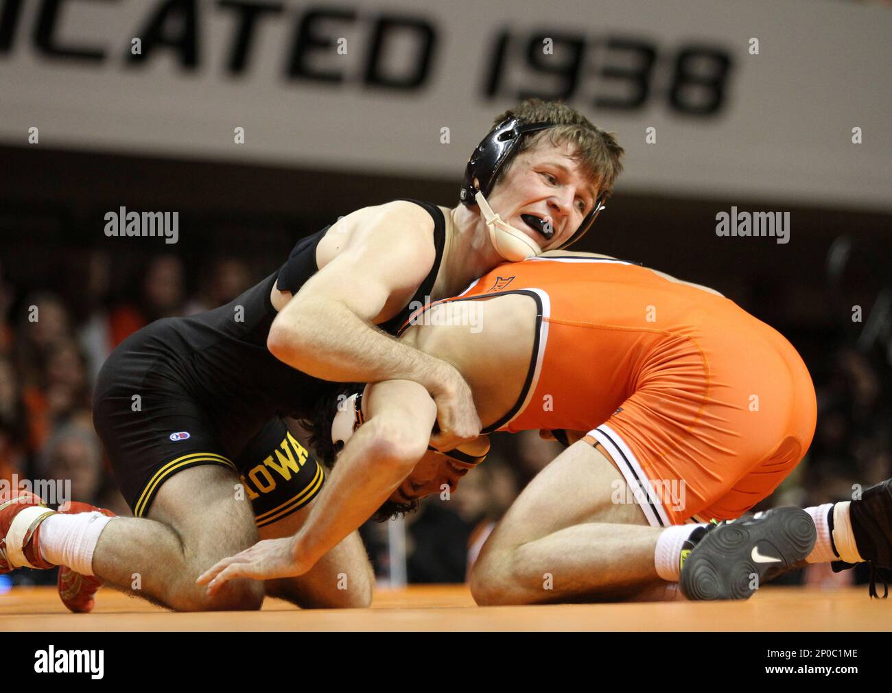 Iowa wrestler Cory Clark holds down Oklahoma State wrestler Kaid Brock