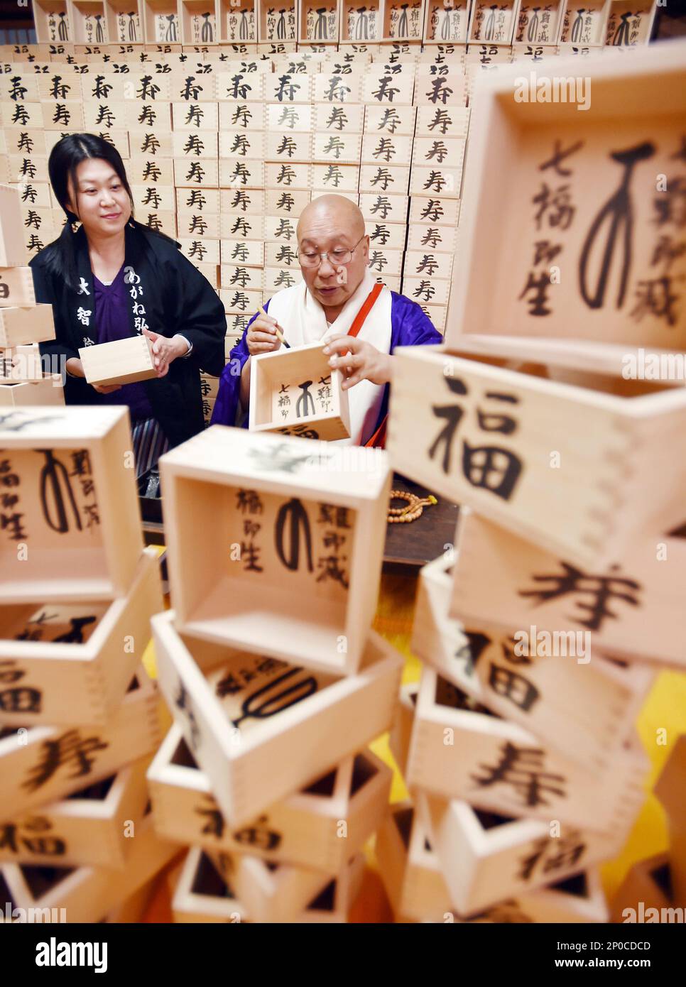 A monk writes fuku (happines) and kotobuki (congratulations) by kanji